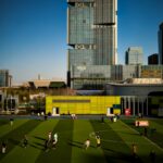 a soccer field in front of a tall building